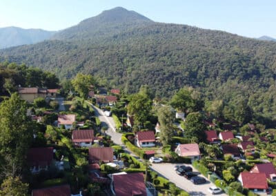 Eine der Haupt-Verbindungsstraßen im Villaggio Olandese mit Parkplatz und Häusern in Hanglage