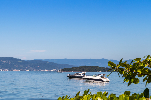 Blick auf eine Yacht auf dem tiefblauen See. In der Umgebung Sonne und Berge